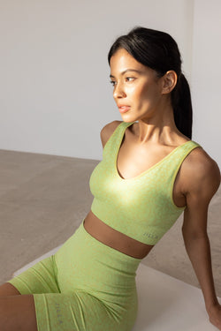 Get summer-ready with our green Sahara Recycled Sports Bra, seamlessly knitted in our new animal jacquard. Designed with a flattering V-neck shape, comfortable straps, and a wide underband, this bra offers light to medium support for low-impact studio exercise, cycling, and gym sessions. The double-layered fabric ensures support and flexibility, while removable pads allow you to customize your fit. Pair it with the matching shorts for a studio-to-street look from sustainable activewear brand.